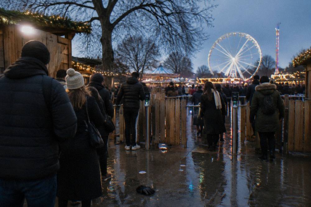 Winter Wonderland entry gates with visitors scanning tickets under festive lights