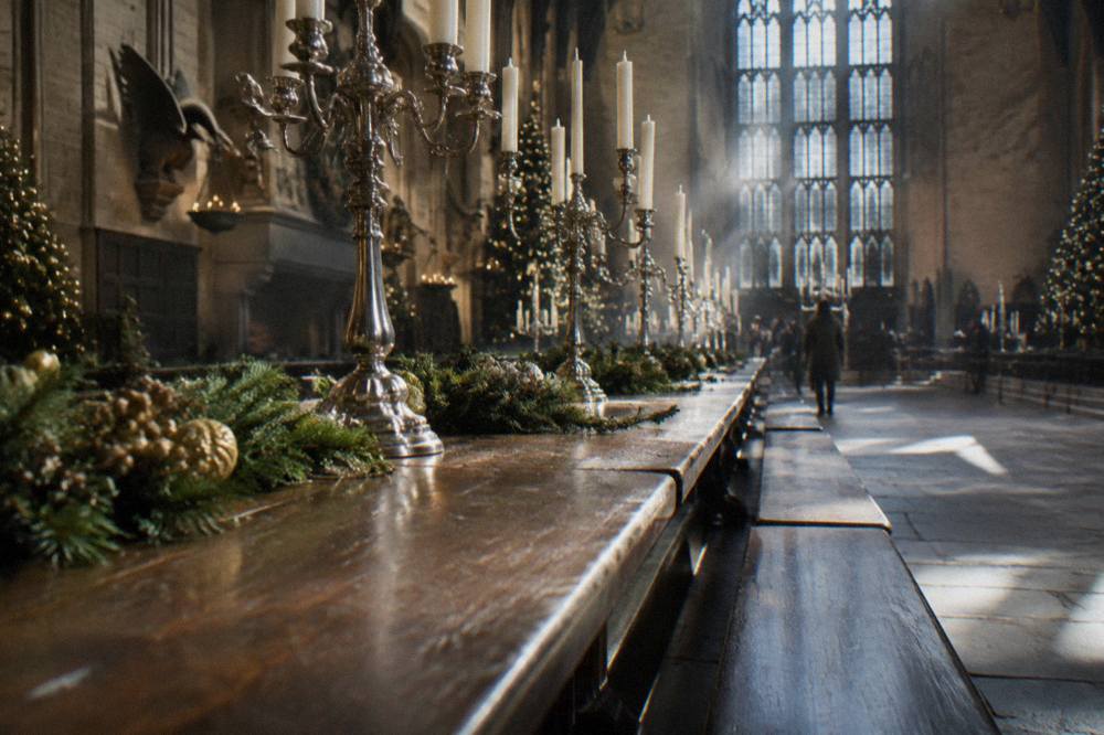 A long table laid for a festive banquet with garlands, candles and silver candelabra