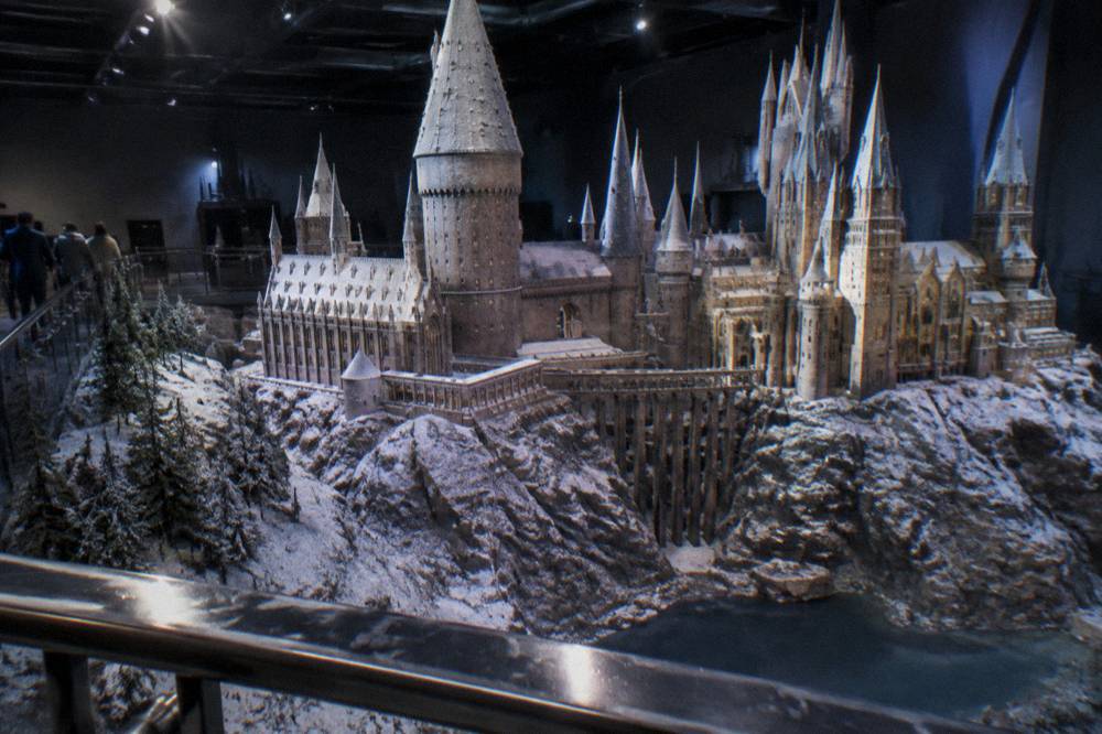 A miniature castle model on a dark plinth under spotlights, rooftops dusted with artificial snow
