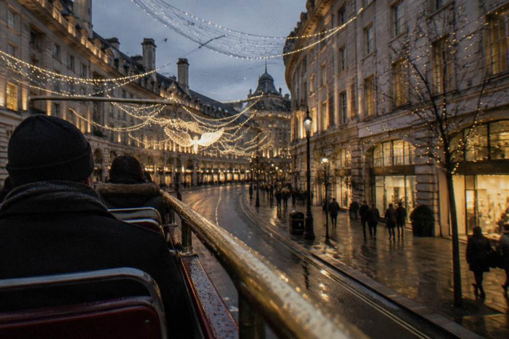 Open-top bus passing under illuminated Christmas street decorations at night