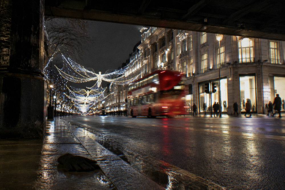 Christmas lights strung across a shopping street glowing after dark