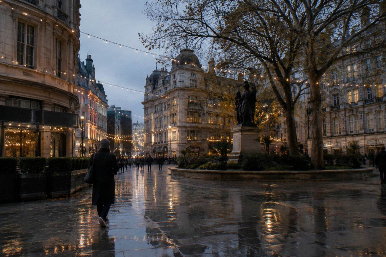 Festively lit London street at dusk with garlands of lights above the road