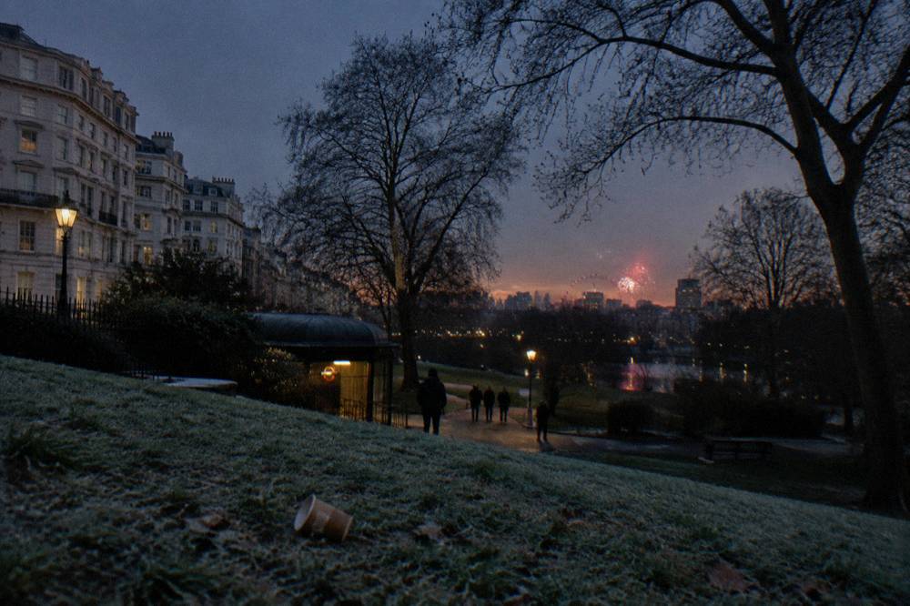 Distant view of fireworks above the London skyline from a park hilltop