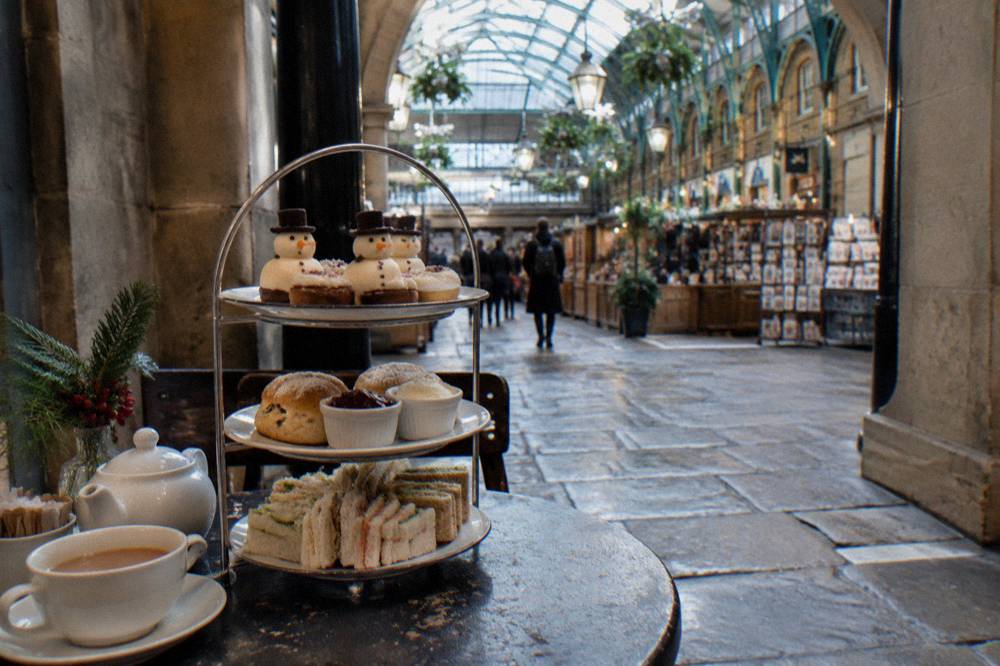 Afternoon tea stand with finger sandwiches and cakes on a decorated table