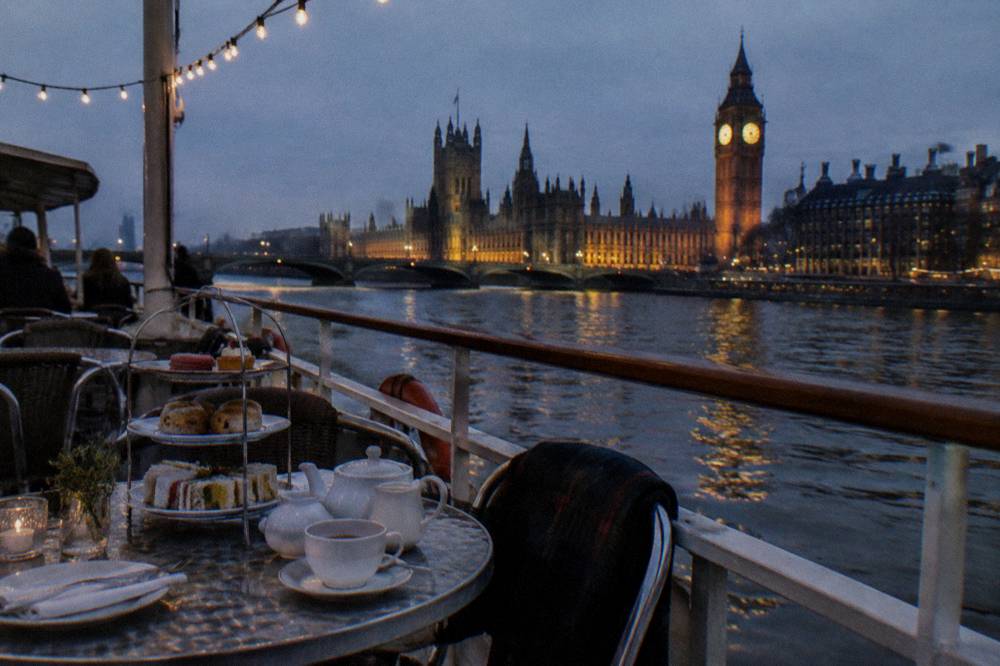 River boat deck with tea tables and city lights reflected on the water