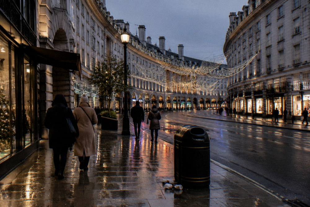 Festively lit London street at dusk with a few people walking
