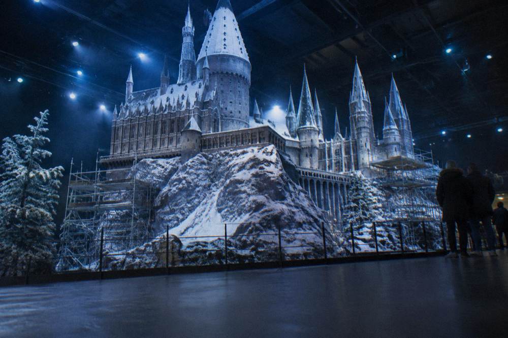Detailed Hogwarts castle model dusted with snow under cool display lighting
