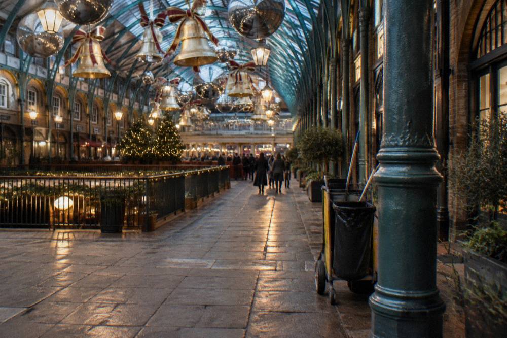 Decorative golden bells and mirror balls hanging inside a covered market hall at night