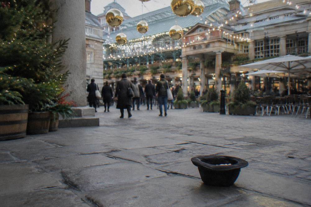 A historic market piazza decorated with oversized golden baubles and strings of white lights