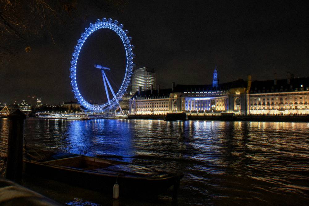 The London Eye and County Hall lit at night from across the Thames